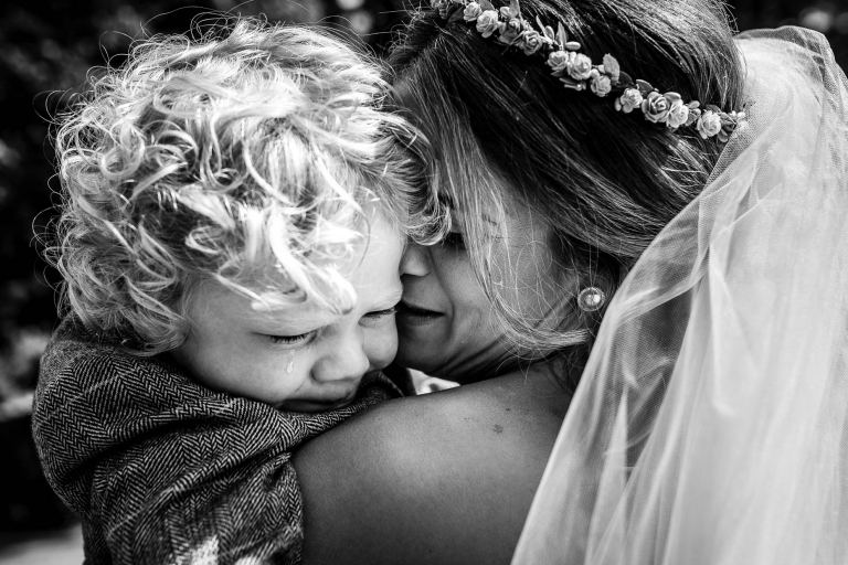 Bride hugs her crying son