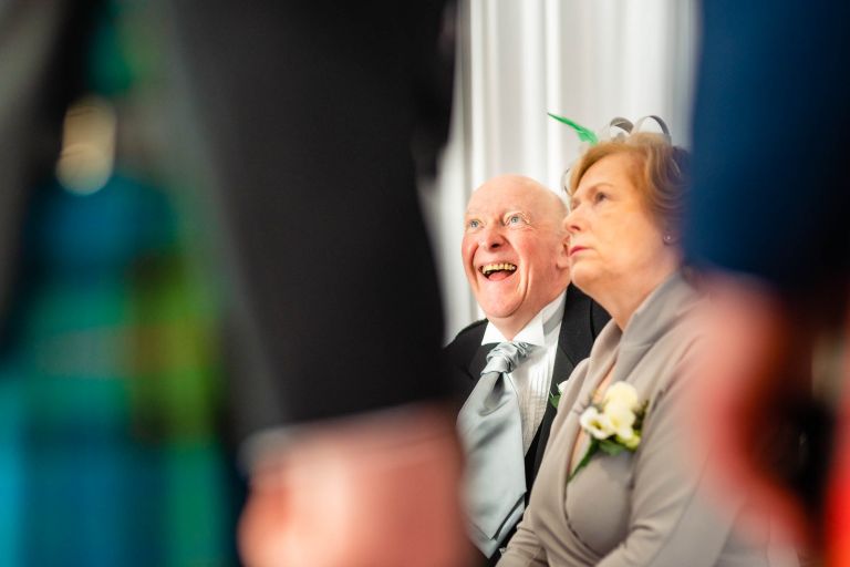 Father of the groom shares a joke with the ushers