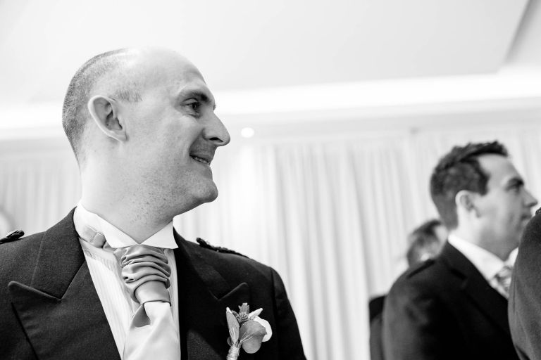 Groom smiles as he watches his bride walk up the aisle