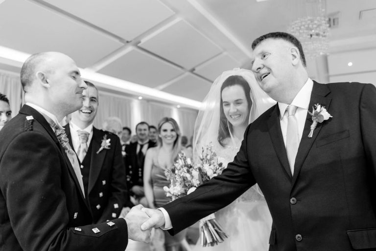 Father of the groom shakes the grooms hand