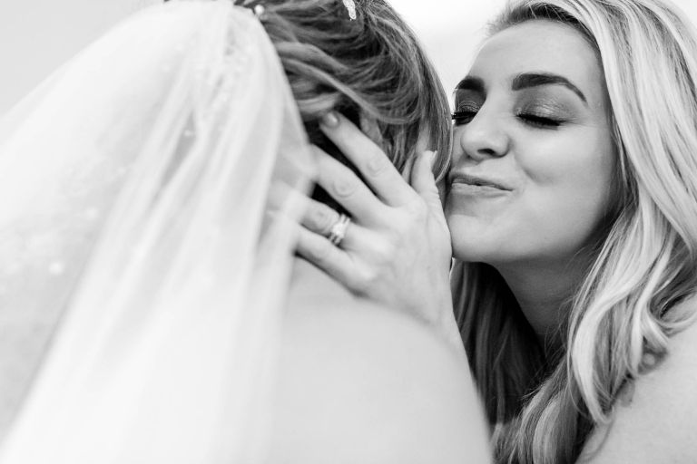 wedding guest gives the bride a kiss on the cheek