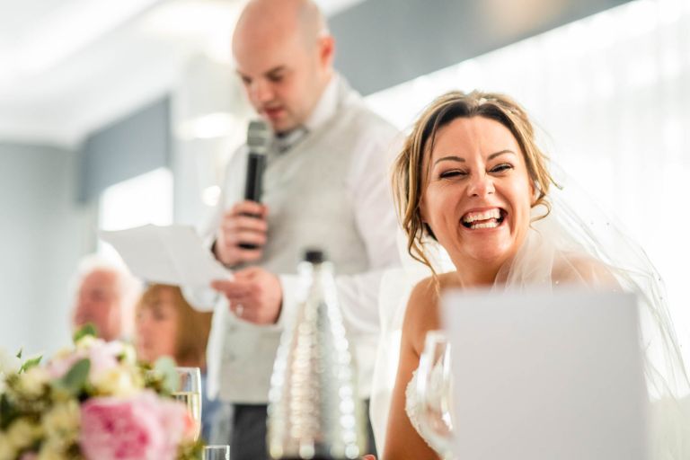 Bride laughing at grooms speech