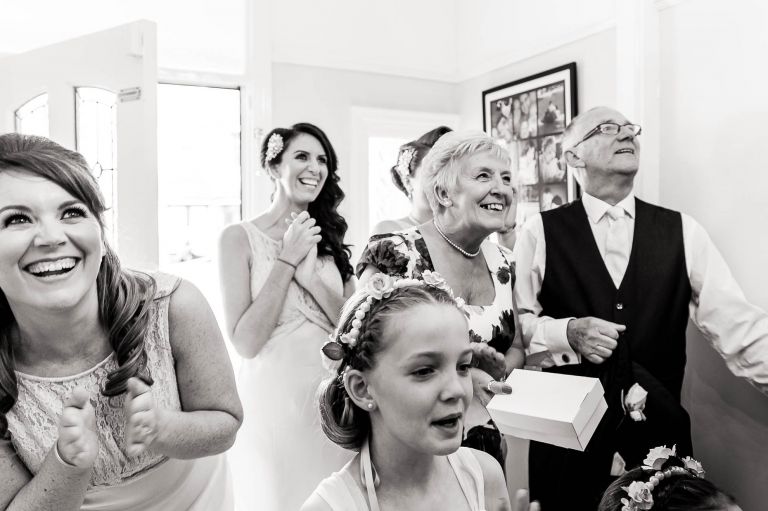 mum and dad and bridesmaids watch bride reveal dress