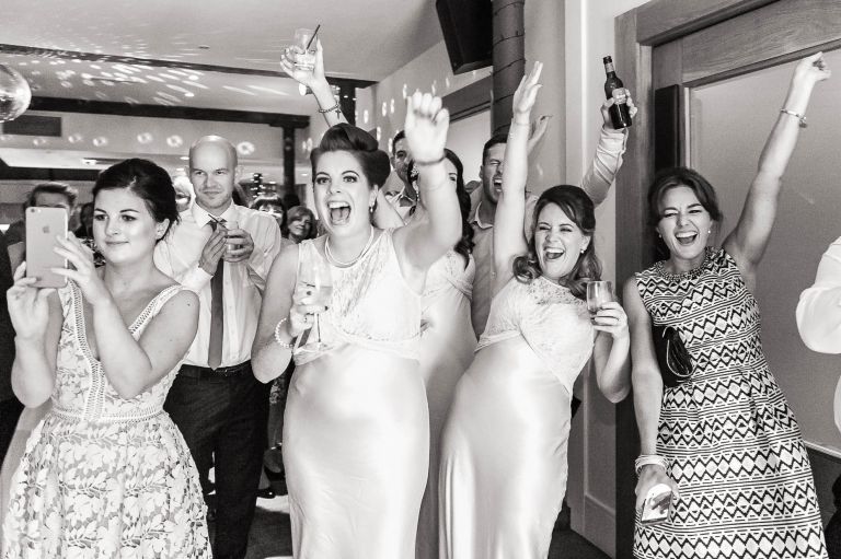 bridesmaids cheer on the newlyweds first dance