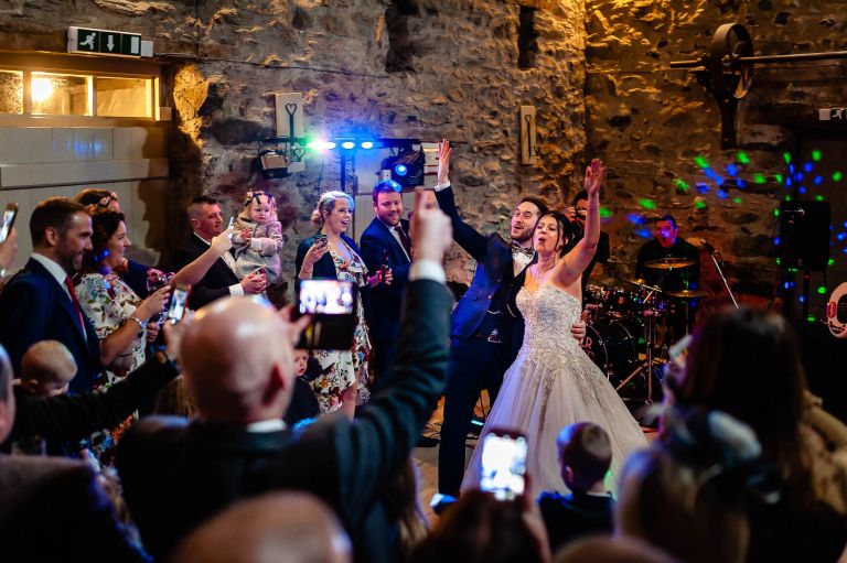 bride and groom wave to guests during first dance