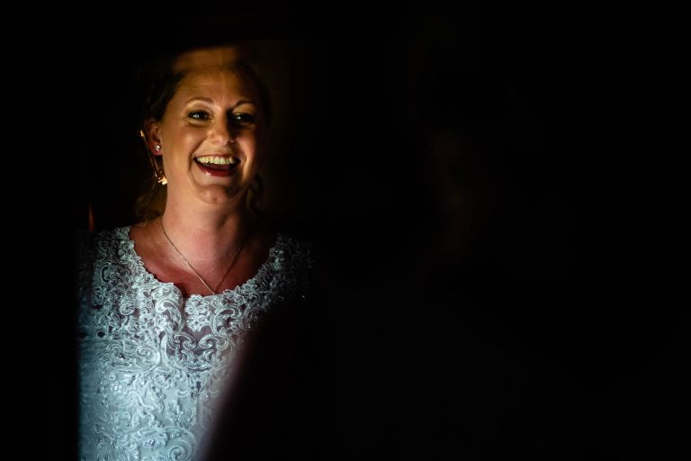 Bride laughing as she looks in mirror