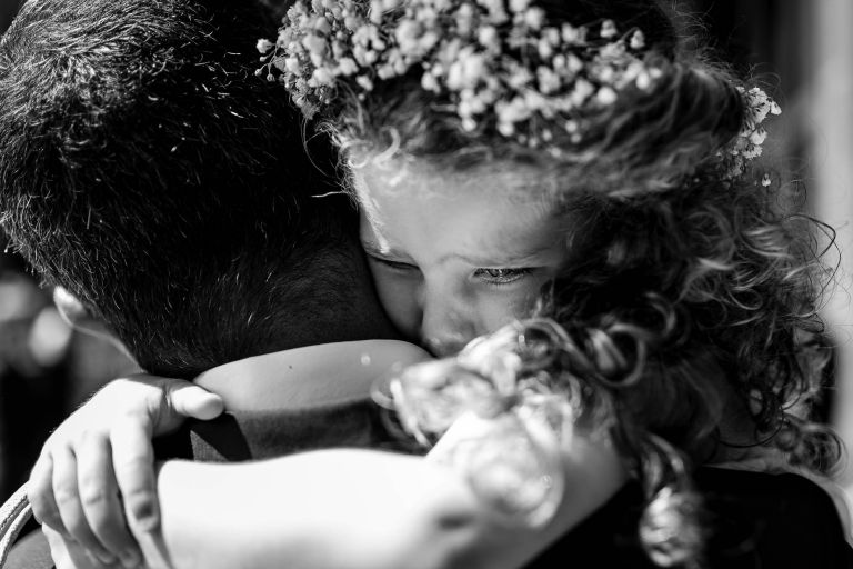 flower girl hugging her father
