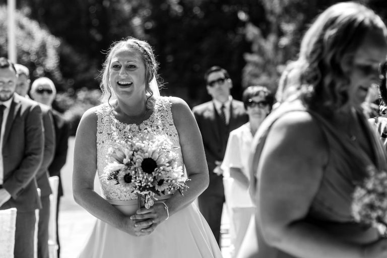 Bride smiles at the groom as she walks up the aisle
