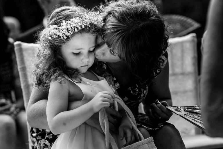 Flower girl gets a kiss from her mother