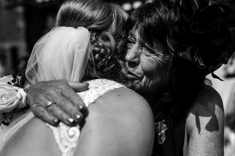 Mother of the groom hugs the bride