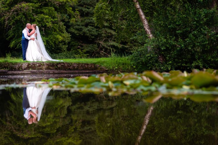 Bride and groom portrait reflection in lake