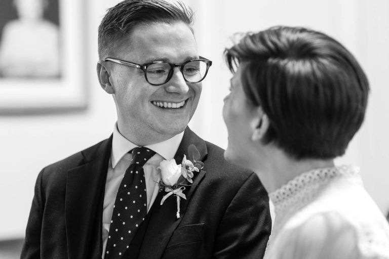 groom smiles at bride during exchange of vows