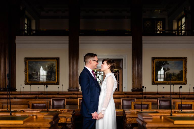 Bride and groom hold each other in council chambers