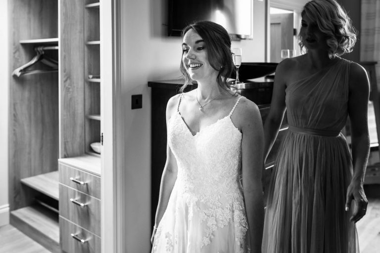 Bride looks in the mirror in her dress
