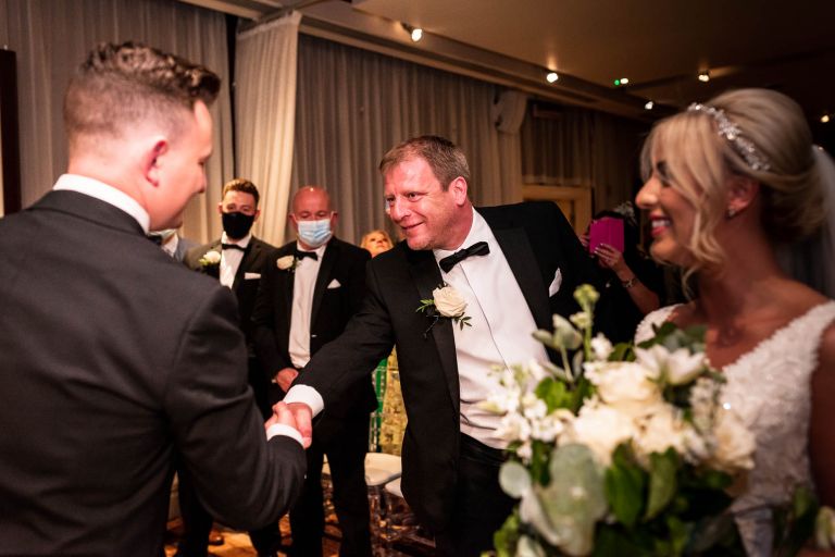 Brides brother shakes grooms hand