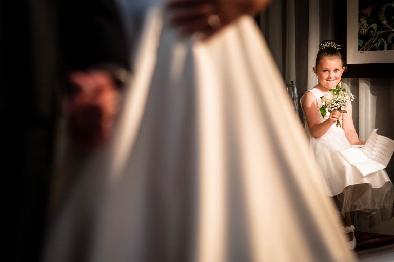 Flower girl watches the bride and groom exchange rings