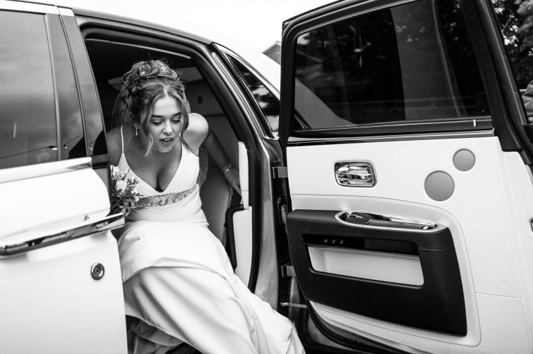 Bride gets out of the wedding car