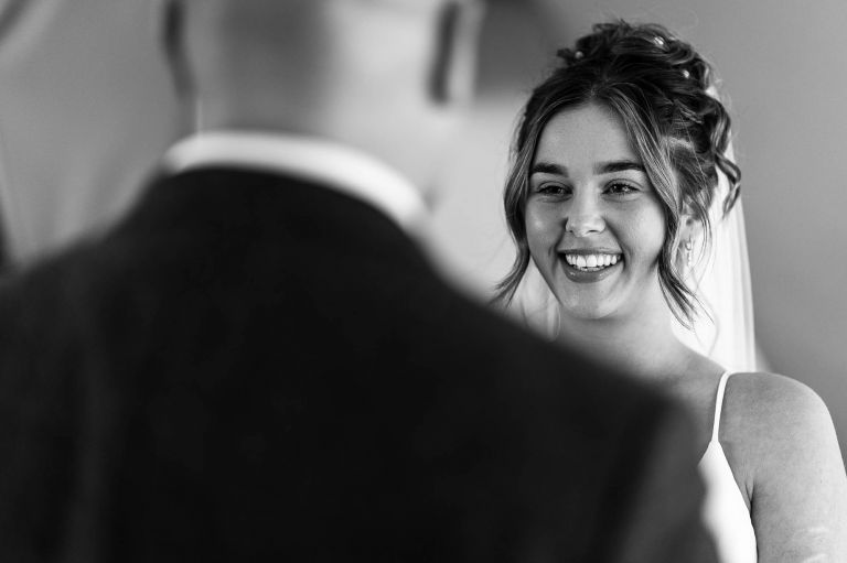 Bride smiles at the groom during exchange of rings