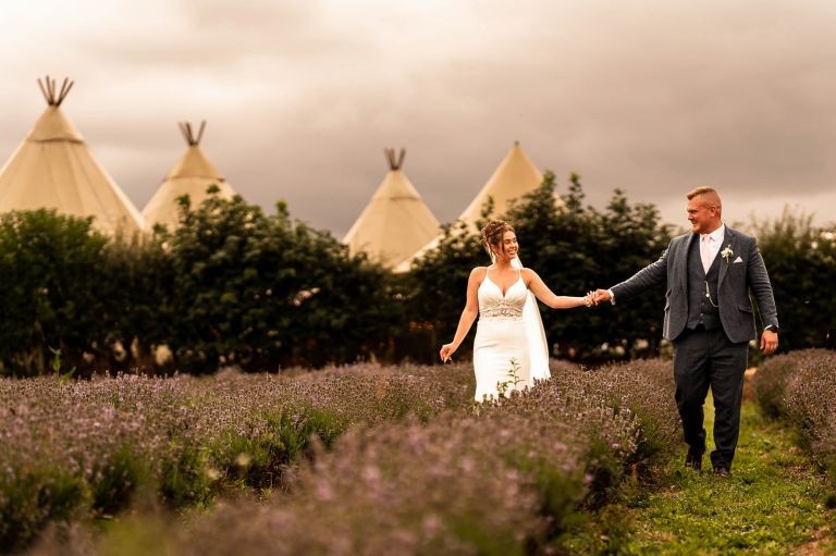 Bride and groom walk through Inglenook farm lavender field