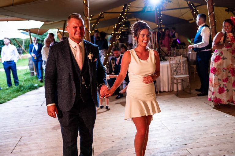 Bride and groom walk onto the dance floor