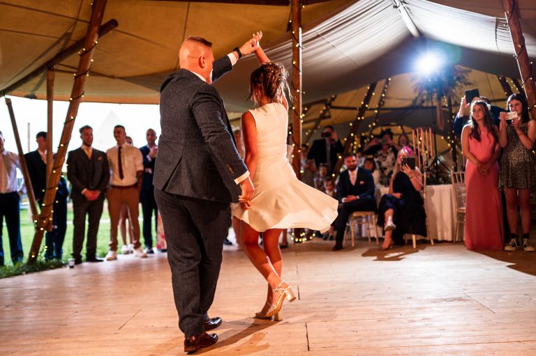 groom spins the bride on the dance floor