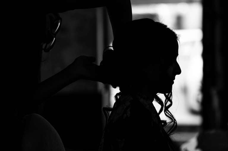 Silhouette of bide having her make up applied