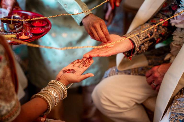the priest places spices on the bride and grooms hands