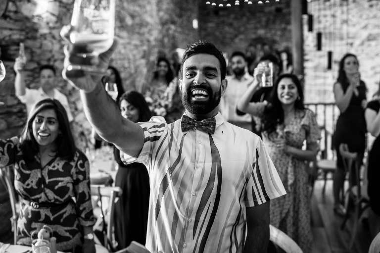 wedding guests raise glasses after grooms speech
