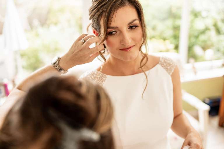 Hairdresser adjusting brides hair