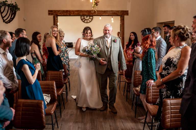 Bride walks up the aisle with the father of the bride