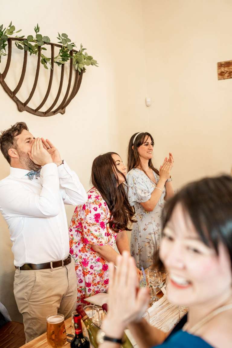 Wedding guests applaud bride and groom 