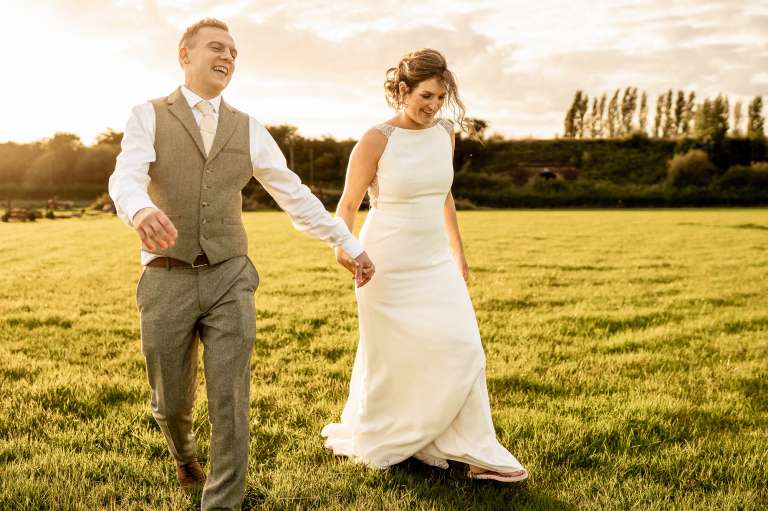 Bride and groom share a joke while walking