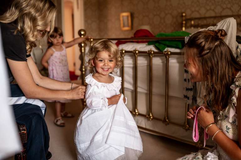 Flower girl being helped into her dress