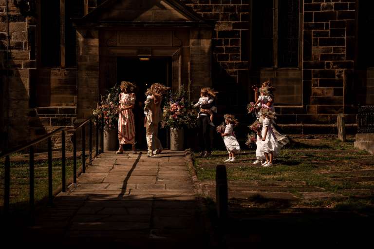 Bridesmaids and flower girls wait at entrance to church
