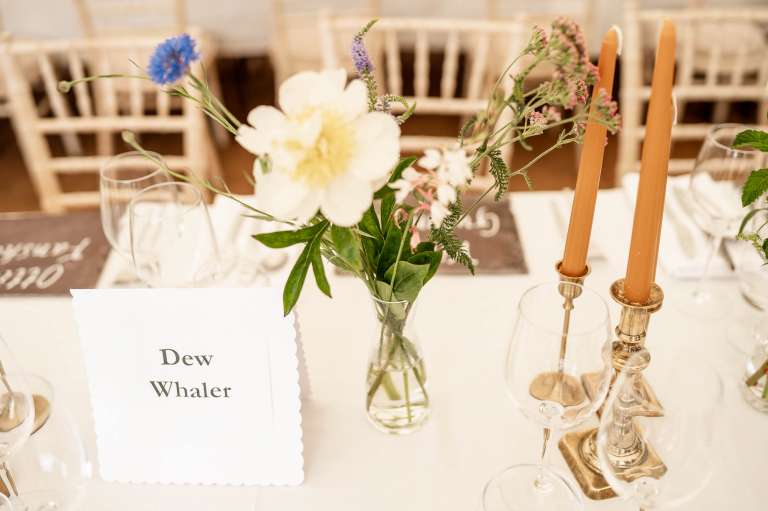 Flowers and place setting at wedding breakfast