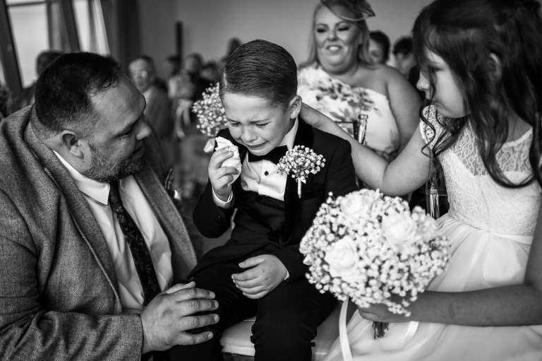 The bride & Grooms son becomes a little overwhelmed after he walks up the aisle before the wedding ceremony