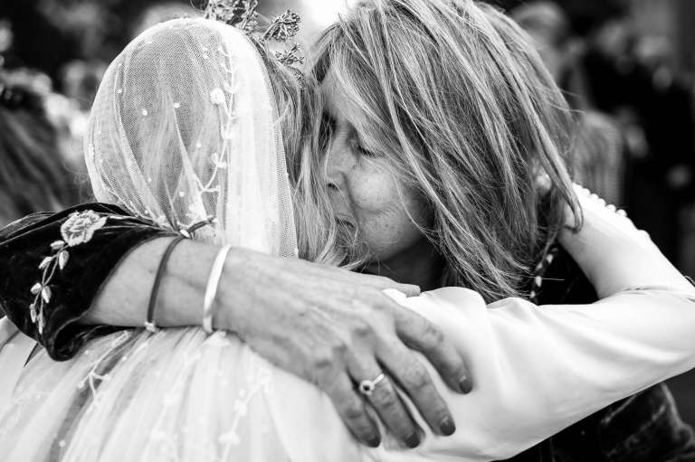 A Wedding guest hugs the bride during the drinks reception. 