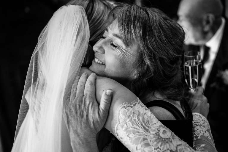 The mother of the bride hugs the bride during the drinks reception 
