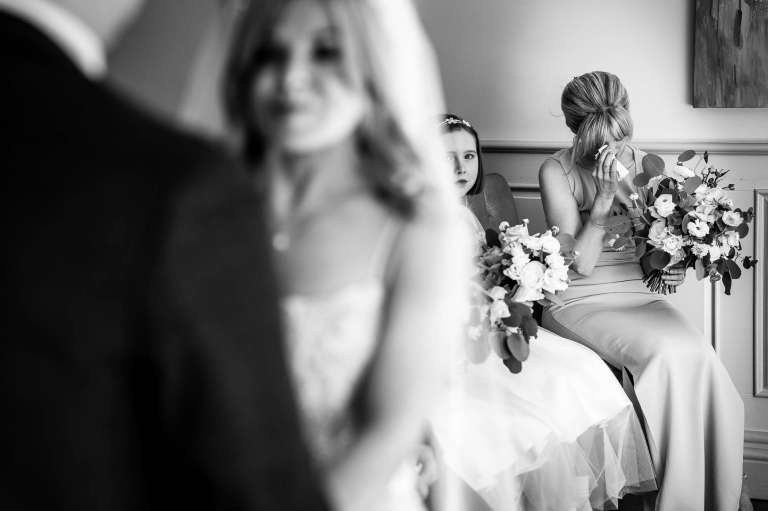 A Bridesmaid wipes away a tear during the wedding ceremony 