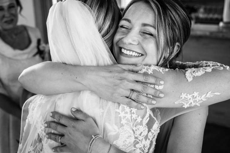 Wedding guest hugs the bride during the drinks reception 