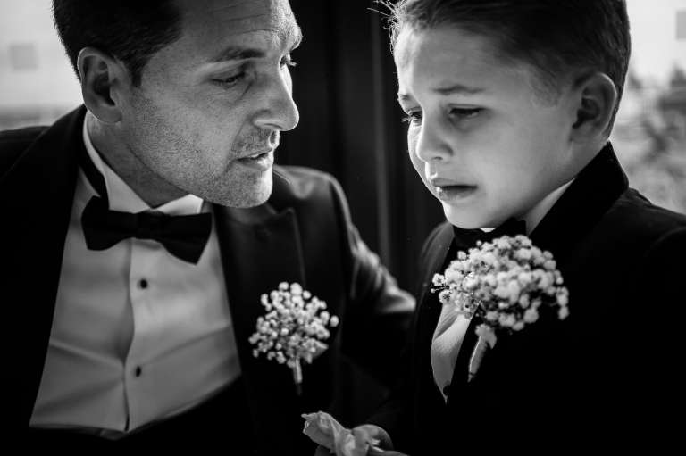 The groom consoles his son after the wedding ceremony